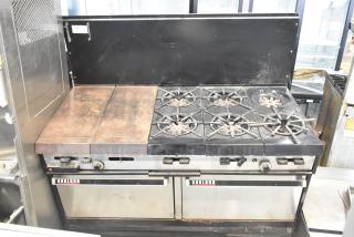 Garland commercial gas-powered griddle with 6-burner range, 2 ovens, and backsplash. Signs of use, model plate visible.