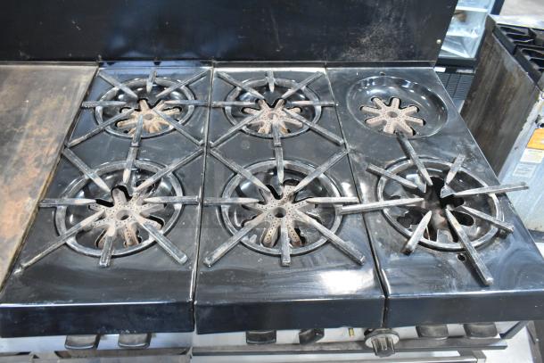 Garland commercial gas flat top griddle with 6 burner range, dual ovens, and backsplash. Appears in used condition.