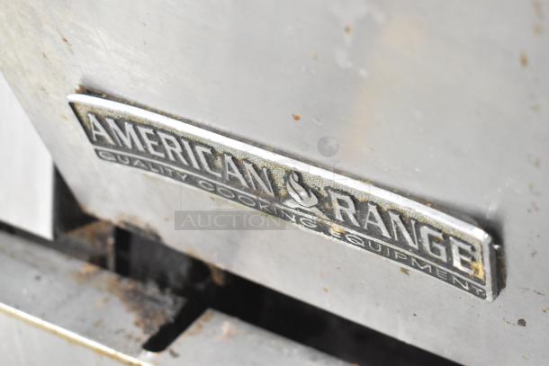 American Range logo on a commercial 6-burner gas range with oven, overshelf, backsplash, and casters. Shows wear.