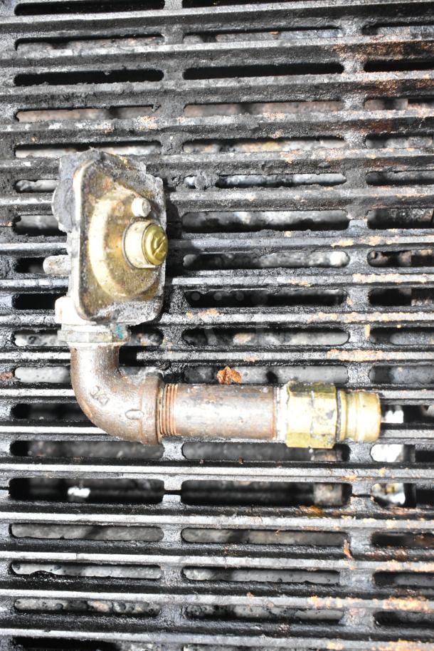 Star Max Commercial Gas Charbroiler Grill with metal pipe detail. Used condition with signs of wear on grates.