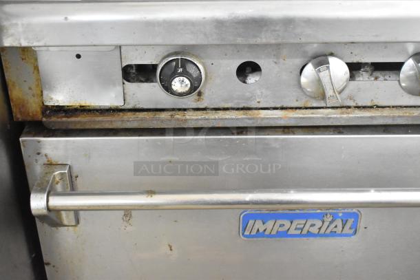 Imperial IR4-G12 commercial gas griddle with oven and back splash. Features visible wear on controls and casing.