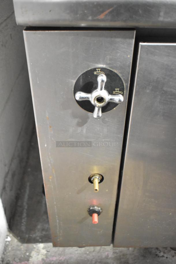 Commercial floor-style pasta cooker with control knobs on stainless steel body, showing light wear and minor rust marks.
