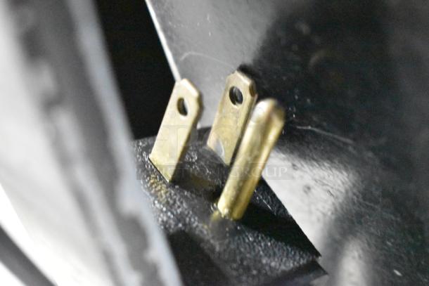 Close-up of an electrical plug prong, part of the 2017 True STG2RPTVLD-2G-2S-HC cooler, indicating 115 volt compatibility.