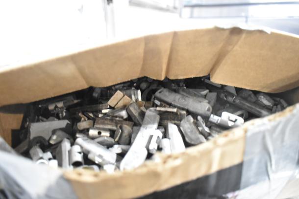 A box of assorted metal parts with various shapes and sizes visible inside.