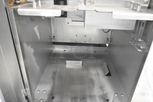 JBT Fresh N Squeeze commercial citrus juicer, floor style, on casters. Interior view, metal construction, 115V, 1 phase.