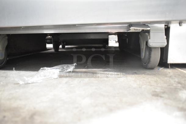 JBT Fresh N Squeeze Commercial Citrus Juicer, 115V, 1 Phase, on commercial casters, visible wheels on concrete floor.