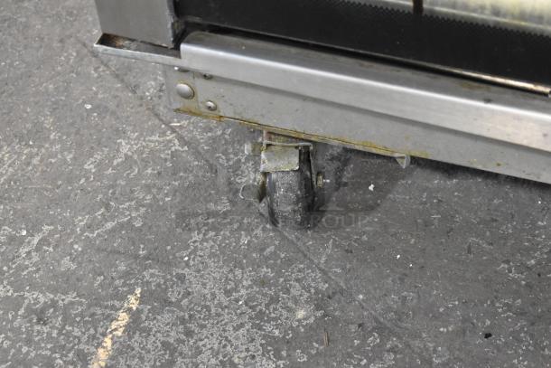 Close-up of a caster on a Hardt Inferno 4500 commercial rotisserie oven, showing wear and metal details.