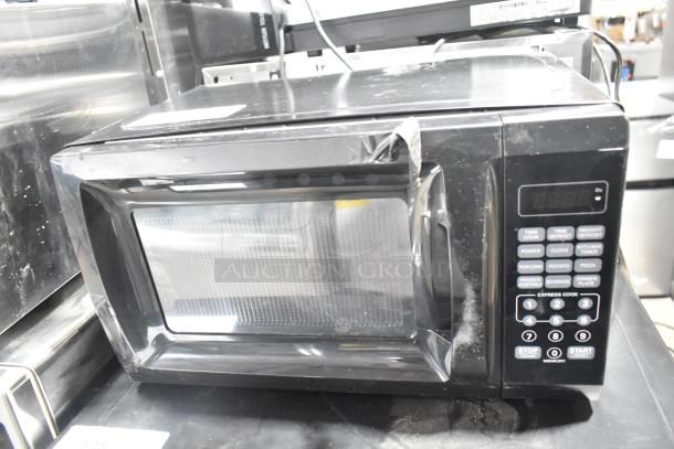 2020 Mainstays EM720CGA-B countertop microwave oven, black, visible control panel, 120 volts, pre-owned condition.