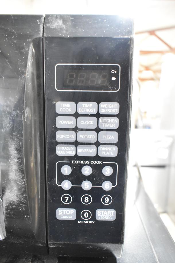 Mainstays EM720CGA-B countertop microwave, black; digital display, touchpad controls, lightly used, 120 Volts, 1 Phase.