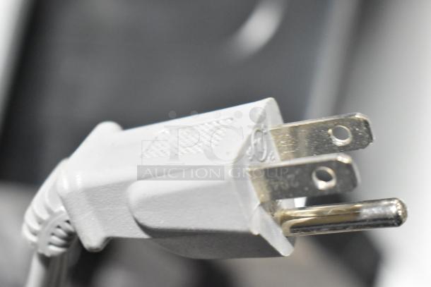 Close-up of a two-prong plug for the 2020 Mainstays EM720CGA-B microwave, 120 volts, showing safety markings.