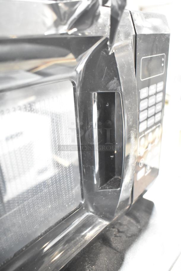 2020 Mainstays EM720CGA-B countertop microwave oven, 120 volts, 1 phase. Features keypad and handle, in used condition.