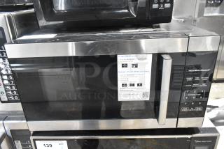 Hamilton Beach HB8436127995-03 countertop microwave oven with stainless steel accents, keypad controls. 120V, 1 Phase. Appears in good condition with instructions label on front.