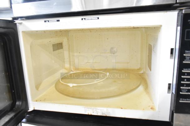 2023 Panasonic NN-SN975S countertop microwave in used condition, interior view showing turntable plate. 120 volts, 1 phase.