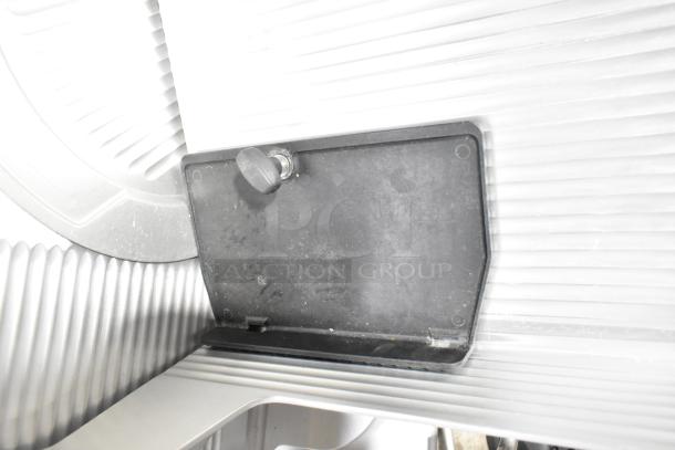 Bizerba GSP H commercial countertop meat slicer, 120 volts, 1 phase. Features a ribbed metal surface and black knob in good condition.