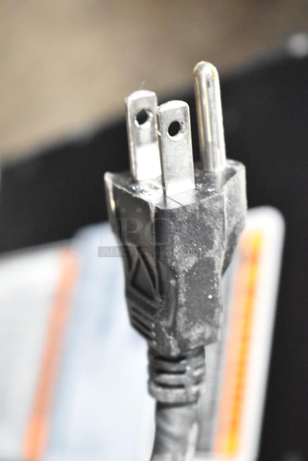 Close-up of a three-pronged plug from a 2021 Bunn VPR coffee brewer, showing slight wear.