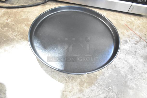 Round black metal tray on a concrete surface, likely from Galanz 667126859 microwave oven. Used as display. No power cord.