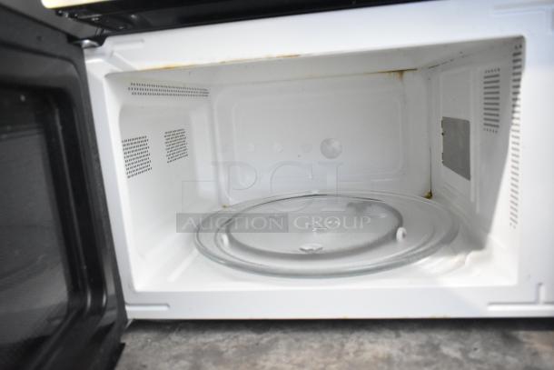 Frigidaire EMW1120 countertop microwave oven, used for display. No power cord. Interior view showing glass turntable. 120V, 1 phase.