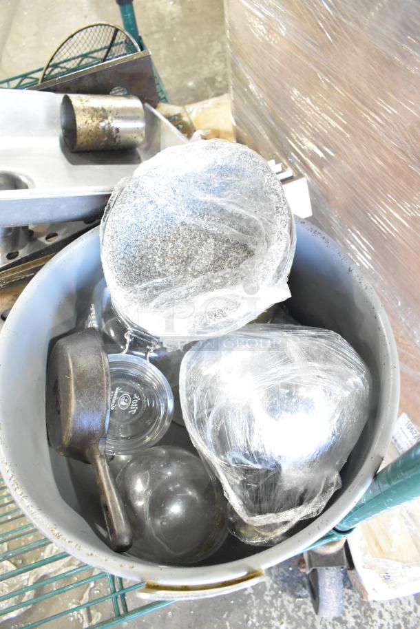 Tiered lot contains skillets, bowls, coffee pot, and metal pot. Mixed condition with visible wear; some items wrapped for protection.