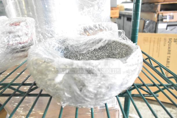 Variety of kitchen items including skillets, bowls, coffee pot, and metal pot, wrapped in plastic wrap on a green shelf.