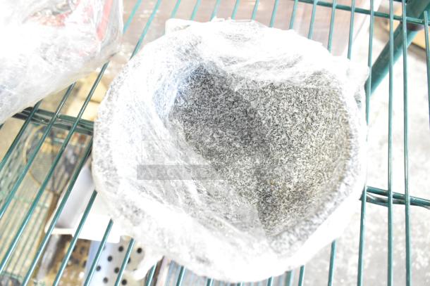 Tier lot including a wrapped granite-look bowl on a metal rack, part of a collection with skillets and pots.