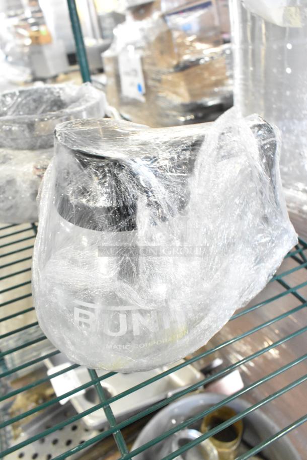 Tier lot of various items including Bunn coffee pot wrapped in plastic, skillets, bowls, and metal pot on a shelf.