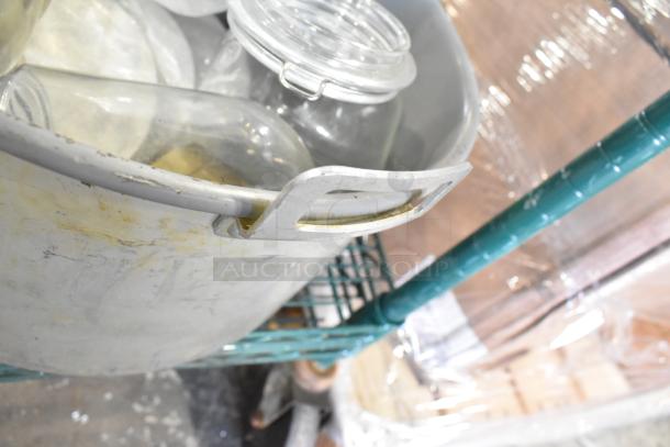 Assorted cookware lot with metal pots, skillets, glass jars. Includes coffee pot. Visible wear on metal surfaces.
