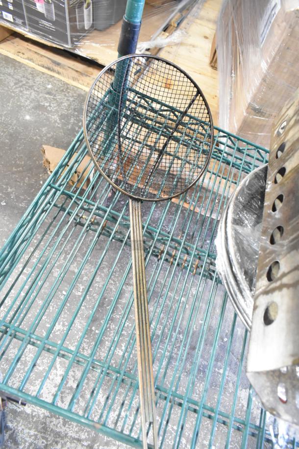 Tiered lot featuring various kitchen items, including a strainer, skillets, bowls, a coffee pot, and a metal pot on a green shelf.