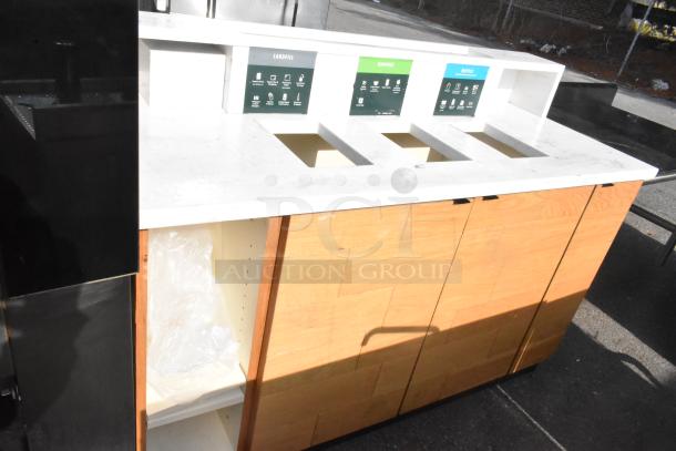 Recycling station with wood paneling and marble countertop, featuring labeled openings for landfill, compost, and recycle.