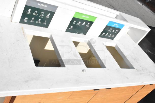 Three-slot trash can shell for sorting landfill, compost, and recycling; includes labeled compartments; wooden base with some wear.