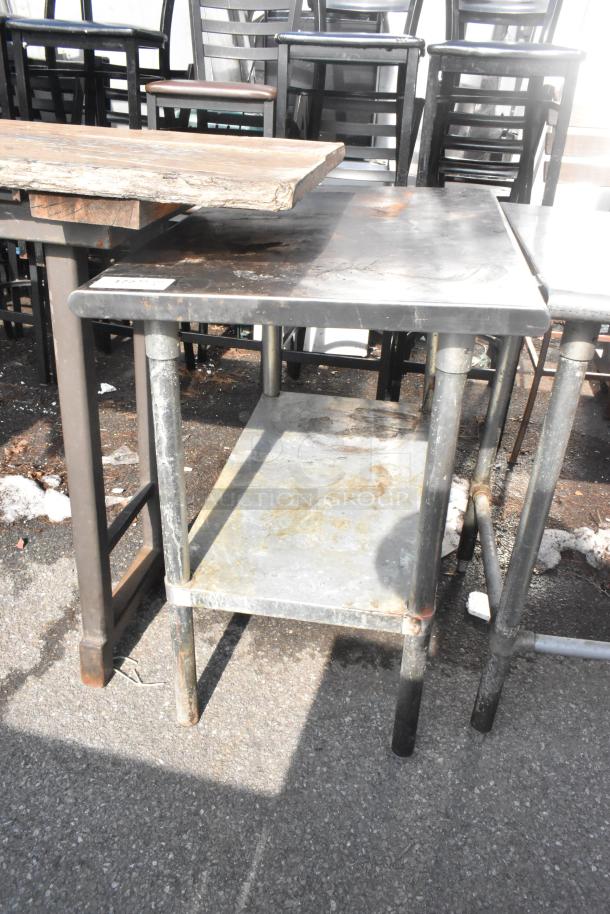 Commercial table with metal under shelf, showing signs of wear and rust. Ideal for industrial or workshop use.
