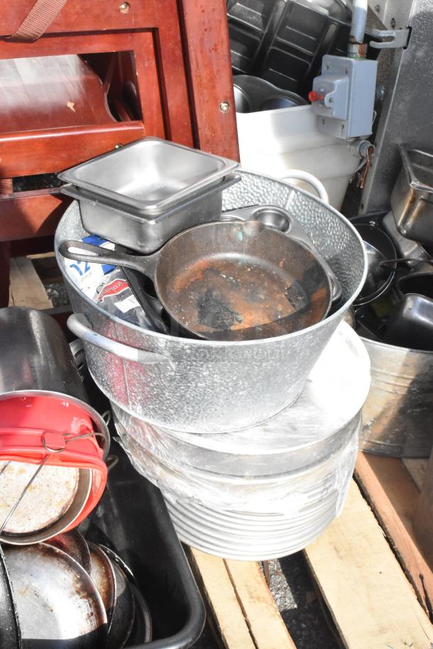 Pallet lot with mixed items including skillets, a red bucket, metal trays, and an evaporator in used condition.