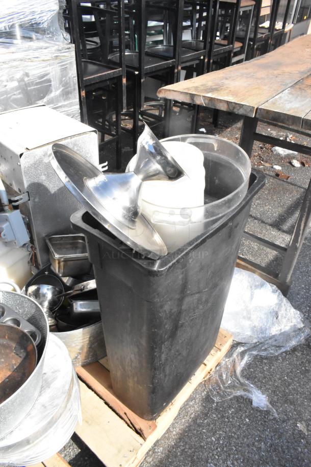 Pallet with assorted items including a black trash can, metal evaporator, high chairs, and skillets. Items appear used.