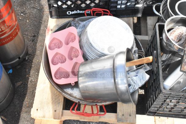Pallet lot with baking pans, skillets, pink heart mold, and metal pot. Items in good condition, mixed types for kitchen use.