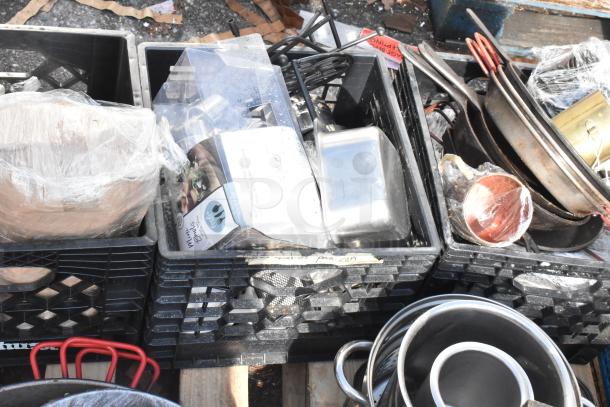 Pallet lot of various items including baking pans, skillets, and kitchenware. Items in crates, some wrapped in plastic.
