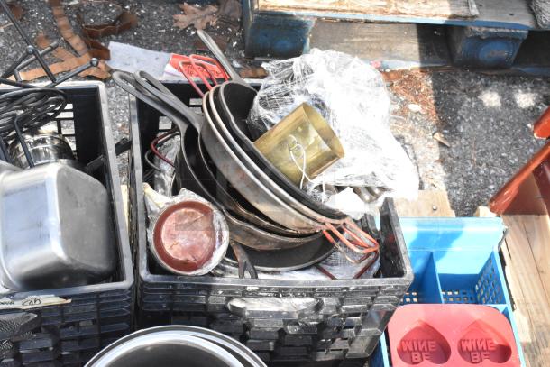 Pallet lot of various items includes baking pans, skillets, and assorted kitchenware. Mixed metal and plastic items in used condition.