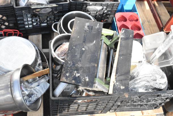 Pallet lot with baking pans, skillets, mixed kitchen items in crates. Various sizes, some wrapped, showing signs of use.