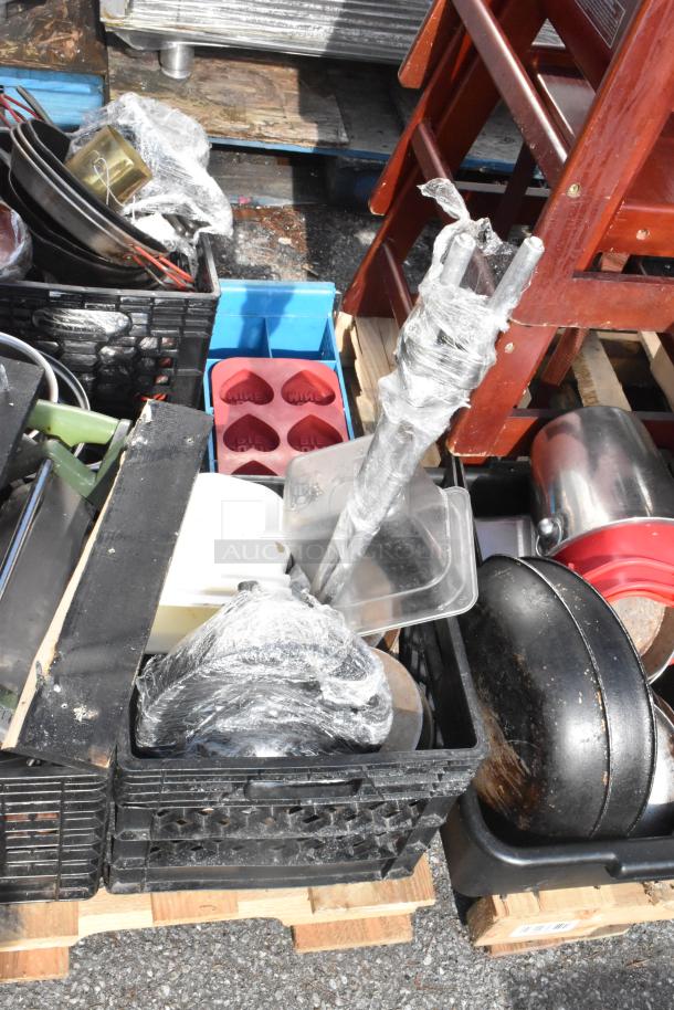 Pallet lot with various items, including baking pans and skillets. Items are in assorted conditions, visible wear and packaging.