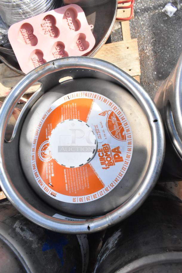 Stack of various kegs, prominently featuring an Rushing Duck Brewing Co. Juice Bomb IPA label. Auction lot of 12 kegs.