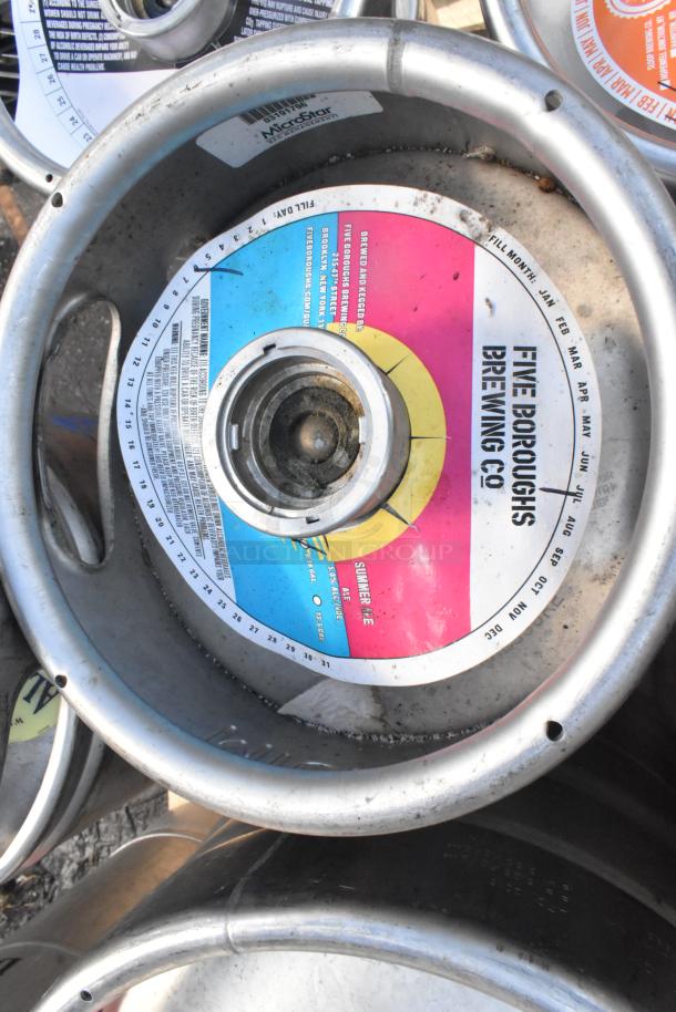 12 various kegs with colorful labels, featuring "Five Boroughs Brewing Co." branding, showing wear and some markings.
