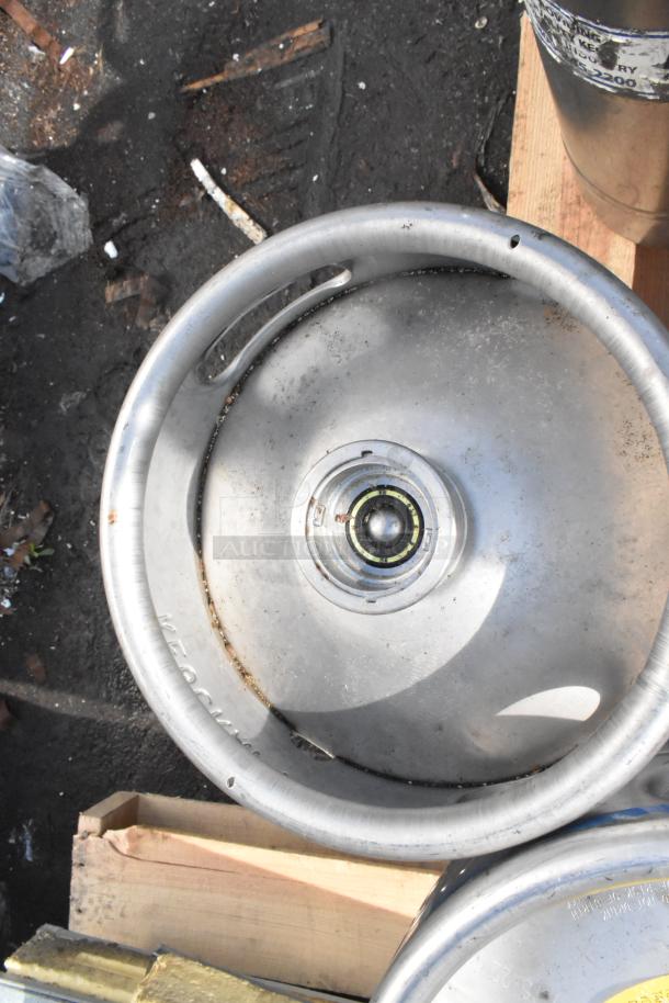 Silver metal keg, top view, showing a central valve. Slight wear visible. Includes 12 kegs total, sold together.