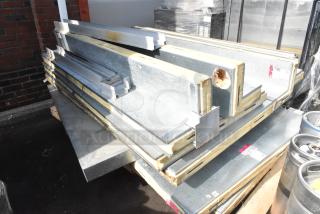 Metal walk-in box panels on a pallet, showing insulation edges and steel exterior, in fair condition with visible wear.