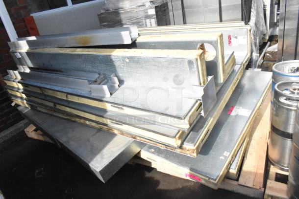 Stack of metal panels and insulation, parts of a walk-in box, showing wear. Labels indicate assembly instructions.