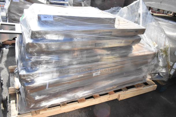 Stack of 10 brand new scratch and dent tabletops, wrapped in plastic on a pallet. Condition and labeling visible.
