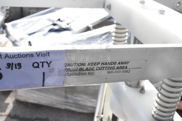 Countertop Pineapple Corer with caution label. Sturdy metal frame, spring mechanism, minor wear. Contact info: Specialty Specialties Inc., 800-545-9362.