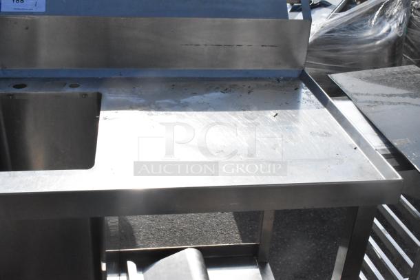 Commercial single bay stainless steel sink with integrated backsplash. Used condition with visible wear. Metal surface.