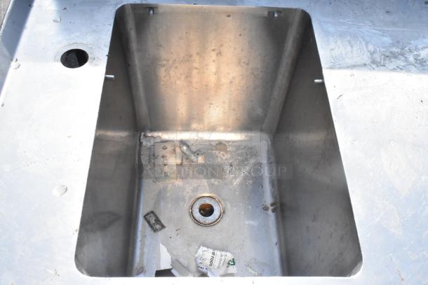 Commercial Single Bay Sink, stainless steel, signs of wear, debris present, visible drain, suitable for heavy-duty use.
