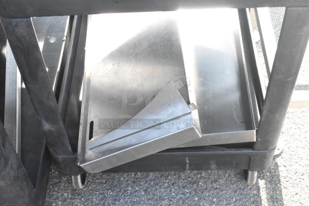 Poly 2-tier cart with commercial casters, holding metal trays. Rugged design, ideal for storage or transport.