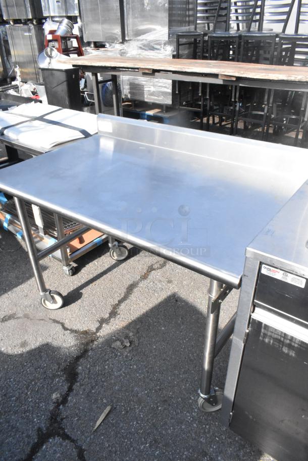 Stainless steel table on commercial casters, with a backsplash and durable construction, suitable for commercial use.