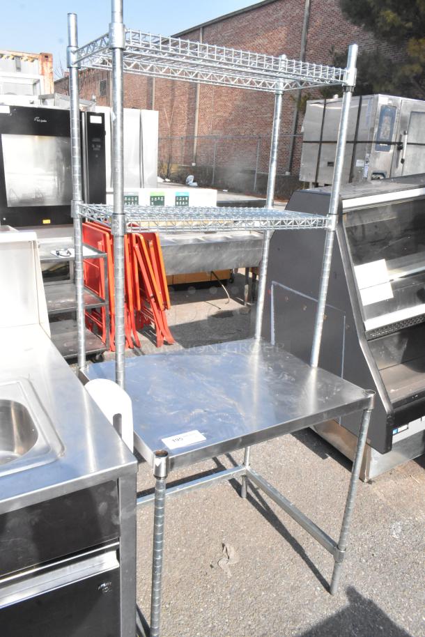 Stainless steel table with two-tier wire shelf overtop, in good condition. Ideal for kitchen use.