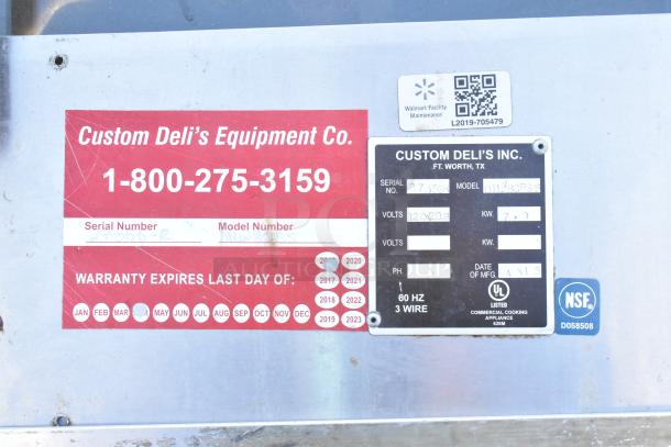 Custom Deli's DILN8CRSS heated display case label showing model, serial number, voltage, and warranty details.